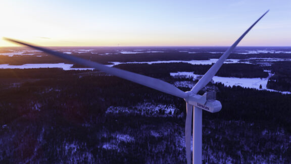 Tuulivoimala Teuvan Paskoonharjun tuulivoimapuistossa ilmasta kuvattuna auringonnousussa.