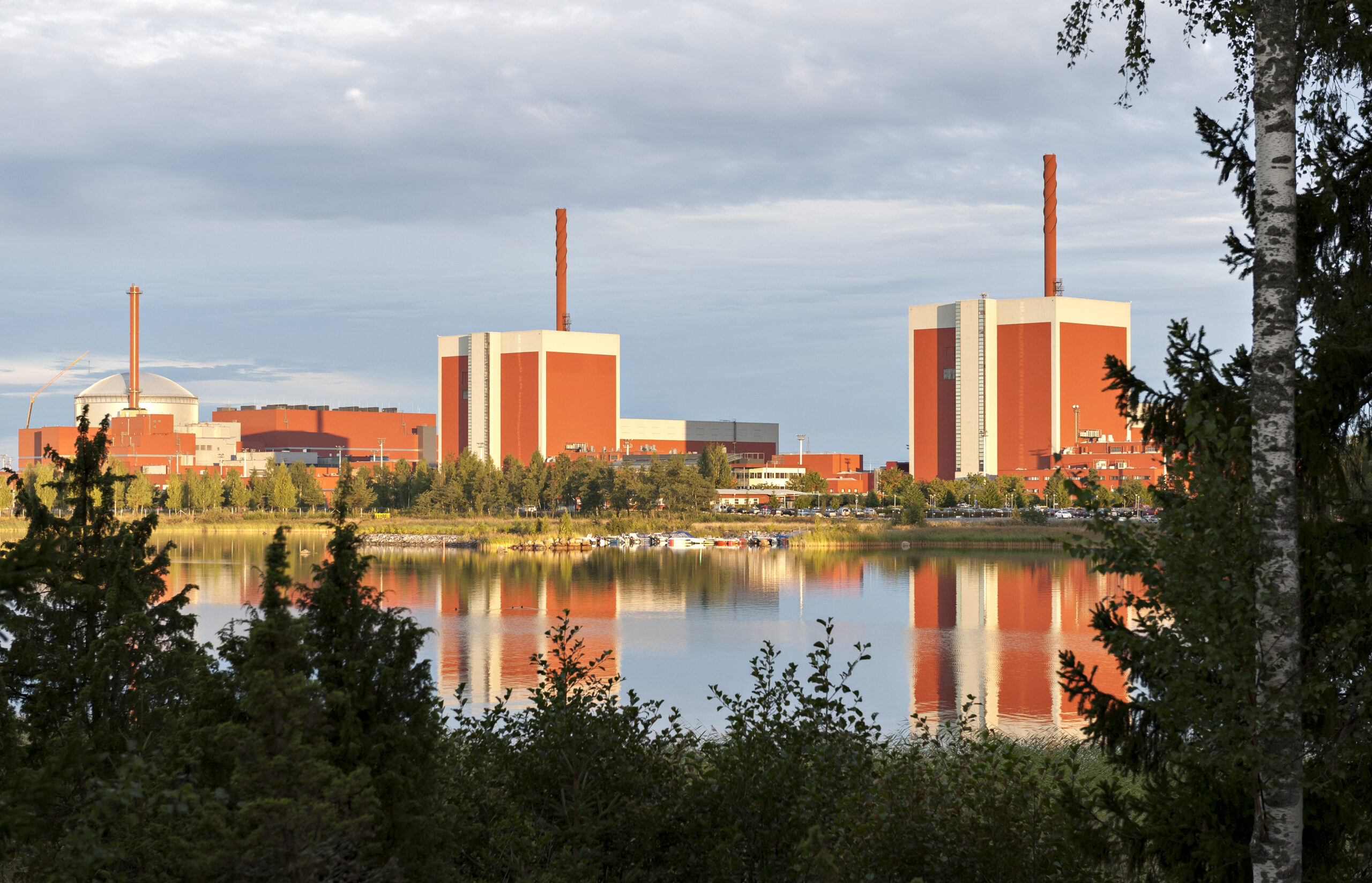 Olkiluodon ydinvoimalaitos vesistön takaa kuvattuna.